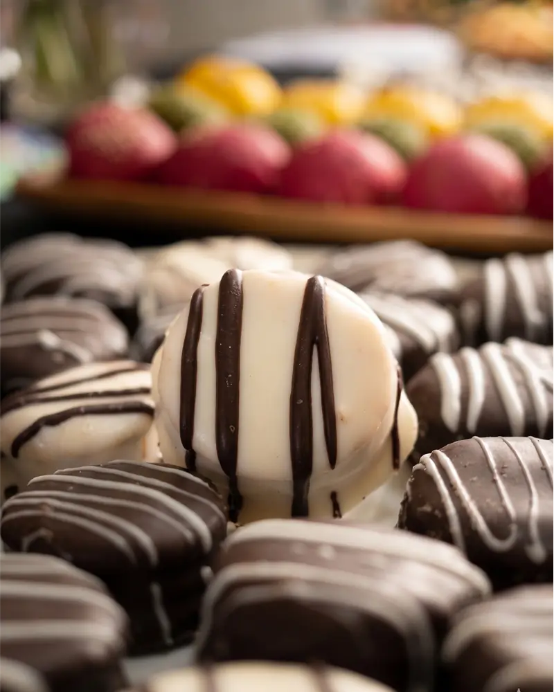 Alfajores de cóctel bañados en chocolate, repostería artesanal para eventos en Santiago.