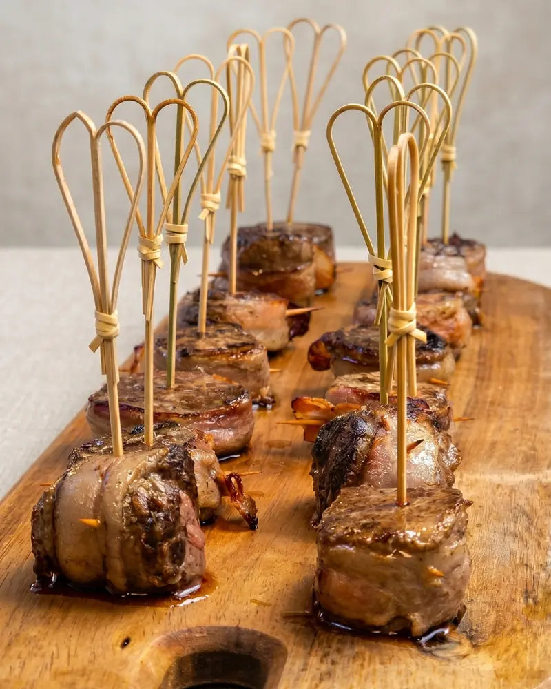 Pinchos de filete con tocino y reducción de vino para eventos gourmet en Santiago.
