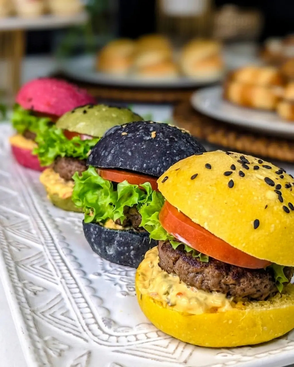Mini hamburguesa gourmet en pan artesanal de color para catering de cumpleaños en Santiago.